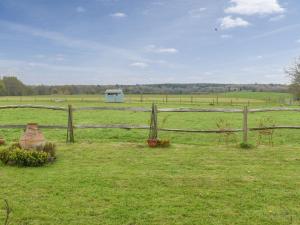 Maresfield的住宿－The Lodge - Oakwood Park Polo Club，田野里带栅栏和椅子的田野