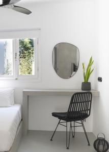 a black chair in a white room with a mirror at 30villa Rd Studio in Rhodes Town