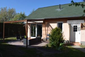 a house with a porch and chairs on a patio at Ferienhaus in der Stienitzaue in Werneuchen