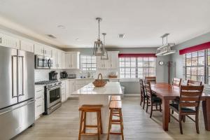 a kitchen with white cabinets and a table and chairs at Herons Nest by VTrips in Galveston