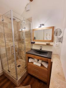 La salle de bains est pourvue d'un lavabo et d'une douche. dans l'établissement gîte Le Maz'eau avec jacuzzi, à Saint-Pierre-de-Chartreuse
