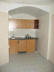 an empty kitchen with wooden cabinets and a sink at Motel Poltava in Poltava