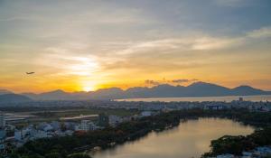 a sunset over a city with a river and a city at Samdi Hotel in Danang