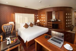a bedroom with a bed and a desk with a laptop at Samdi Hotel in Danang