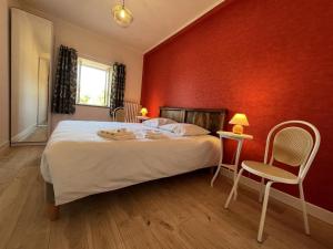 a bedroom with a bed and a red wall at Domaine de Bisseret : Gîte pour golf et détente au cœur de la France - FR-1-489-438 in Lavault-Sainte-Anne
