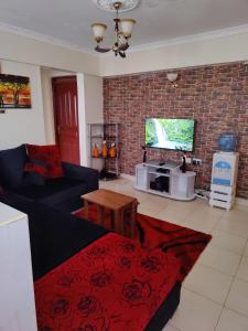 uma sala de estar com um sofá e uma televisão em Modern 1-bdrm Apartment 15min to CBD. 20min to UN em Nairobi