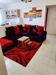 uma sala de estar com um sofá preto e uma mesa em Modern 1-bdrm Apartment 15min to CBD. 20min to UN em Nairobi