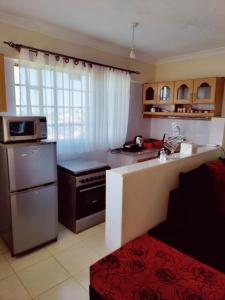 uma cozinha com um frigorífico e um fogão forno superior em Modern 1-bdrm Apartment 15min to CBD. 20min to UN em Nairobi