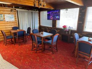 uma sala de conferências com mesas e cadeiras e uma televisão em Love Hotels Western Holiday at Harlan Lake NE em Alma