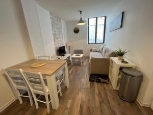 een woonkamer met een tafel en een bank bij Grand studio, chambre séparée, calme, centre ville prox Cathédrale - parking possible in Orléans