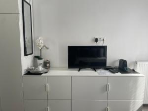 a tv sitting on top of a white cabinet at EXECUTIVE DOUBLE ROOM WITH EN-SUITE in GUEST HOUSE RUE TREVIRES R3 in Luxembourg