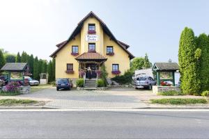 ein gelbes Haus mit einem Schild auf der Vorderseite in der Unterkunft Landferienhaus Pension Erika in Görmar