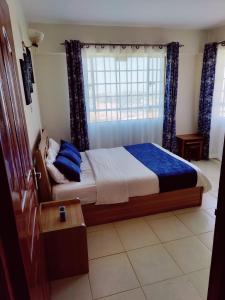 um quarto com uma cama e uma janela em Modern 1-bdrm Apartment 15min to CBD. 20min to UN em Nairobi