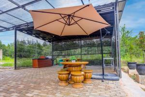un patio con tavolo e ombrellone di SPOT ON 92523 Homestay Pasir Padi Permai Syariah a Pangkal Pinang