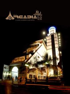 a building with a clock tower at night at Hotel Arcadia in Kottayam