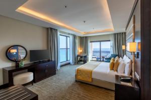 a hotel room with a bed and a television at Al Bahar Hotel & Resort in Fujairah