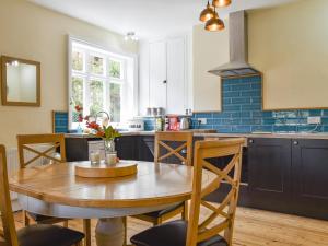 cocina con mesa de madera y comedor en Upper Broughton Farm Cottage, en Snead