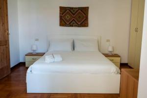 a white bed in a room with two night stands at Spacious apartment in strategic location - Green in Trento