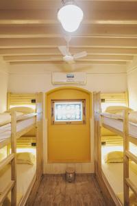 Habitación con 3 literas y puerta amarilla. en GoSolo Stays, en Bombay