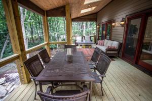 a wooden table and chairs on the porch of a cabin at Red Bird Retreat in Beech Mountain +34 photos