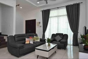 a living room with a black couch and a coffee table at Casa Le Deer 鹿小居 in Kuah