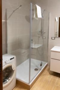 La salle de bains est pourvue d'une douche et d'un lave-linge. dans l'établissement Flaminio New Apartment, à Rome