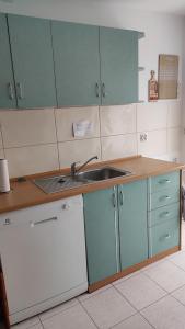 a kitchen with blue cabinets and a sink at Pokoje Przy Kominie in Piecki