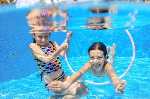dos chicas jugando con mangueras en una piscina en Beautiful 4 Berth Lodge With Decking At Manor Park In Hunstanton Ref 23038c, en Hunstanton