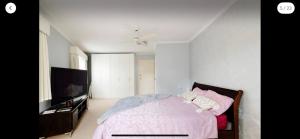1 dormitorio con 1 cama y TV de pantalla plana en Guest ensuite 7 minutes from airport, en Melbourne