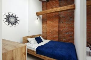 1 dormitorio con 1 cama contra una pared de ladrillo en Apartamenty na Starym Mieście, en Gliwice