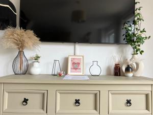 a dresser with vases and plants on top of it at Central, Cosy & Stylish Home with Large Garden, Bournemouth in Bournemouth