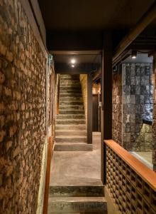 a stairway in a building with a stone wall at Domo Japanese Style Bedroom in Melaka