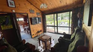 a living room with a couch and a tv in a cabin at Fantail Garden in Walton