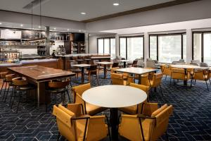 un ristorante con tavoli, sedie e finestre di Courtyard by Marriott Portland Beaverton a Beaverton