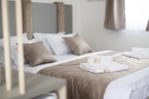 two beds with white pillows and towels on them at Reset Boutique Hotel in Budva