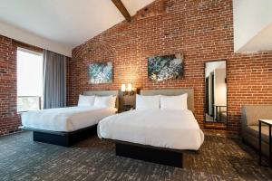 a hotel room with two beds and a brick wall at Columbus Marriott in Columbus