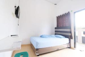 - une petite chambre avec un lit et un bureau dans l'établissement SPOT ON 92536 Teguh Homestay Syariah, à Parit