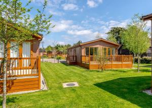 a large yard with a house with a deck at Canterbury Reach Lodge Retreat in Petham