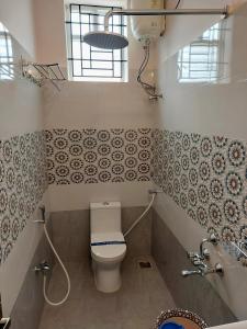a bathroom with a toilet and a sink at Hotel RK - Temple Stay in Thanjāvūr