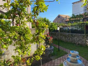 - un jardin avec piliers en pierre dans la cour dans l'établissement Gather Inn Guest House, à Shkodër
