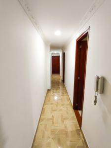 a hallway with white walls and a tile floor at Apartamento en Laureles con Excelente Ubicación in Medellín