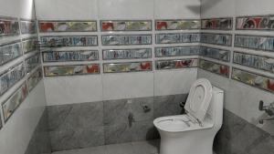 a bathroom with a toilet and shelves of food at Loghouse at khajjiar lake in Khajjiar 