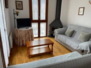 sala de estar con sofá y mesa con TV en Apartaments Pirinenc en Esterri d'Àneu