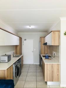 a kitchen with wooden cabinets and a washer and dryer at The Blyde riverwalk estate in Pretoria