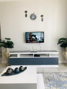 a living room with a tv on a white wall at The Blyde riverwalk estate in Pretoria