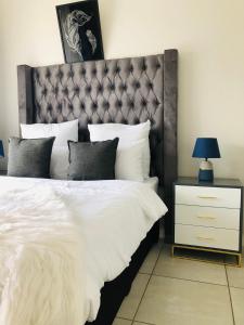 a bedroom with a large bed with a headboard at The Blyde riverwalk estate in Pretoria