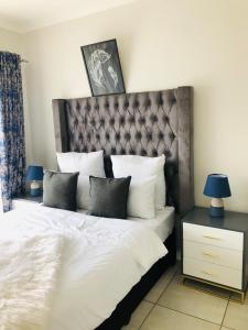 a bedroom with a large bed with white sheets and pillows at The Blyde riverwalk estate in Pretoria