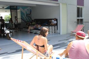 Eine Frau im Bikini, die auf einem Deck sitzt. in der Unterkunft Port Douglas Backpackers in Port Douglas