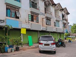 un coche blanco estacionado frente a un edificio en SPOT ON 92538 Joyoakis Homestay Syariah en Nagoya