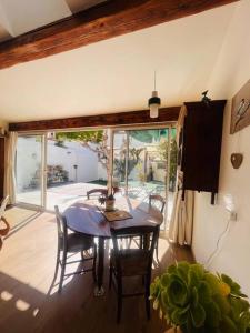 a dining room with a table and chairs and a window at Le jardin du roucas in Marseille